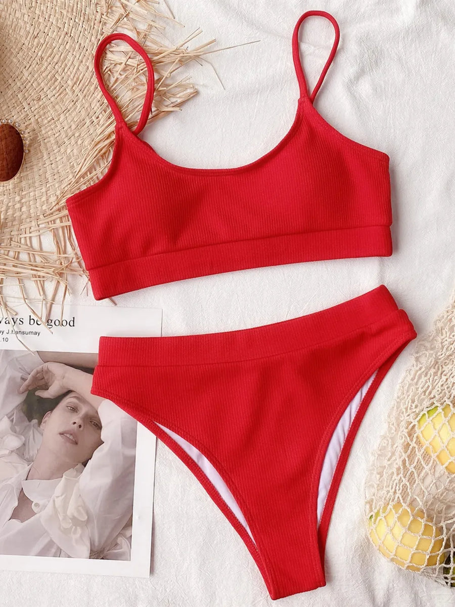 Red bikini set on a white surface with a blurred background