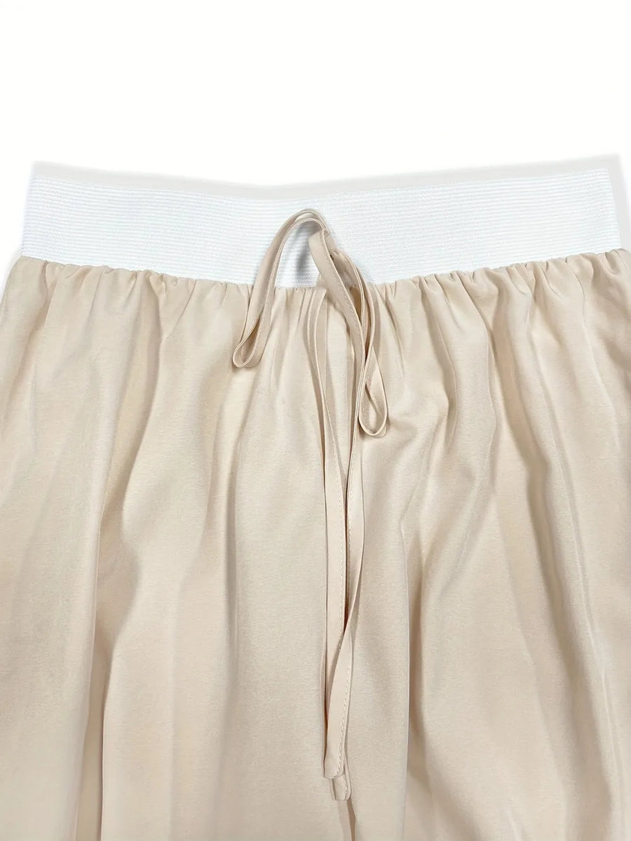 Beige pants with a white waistband on a white background