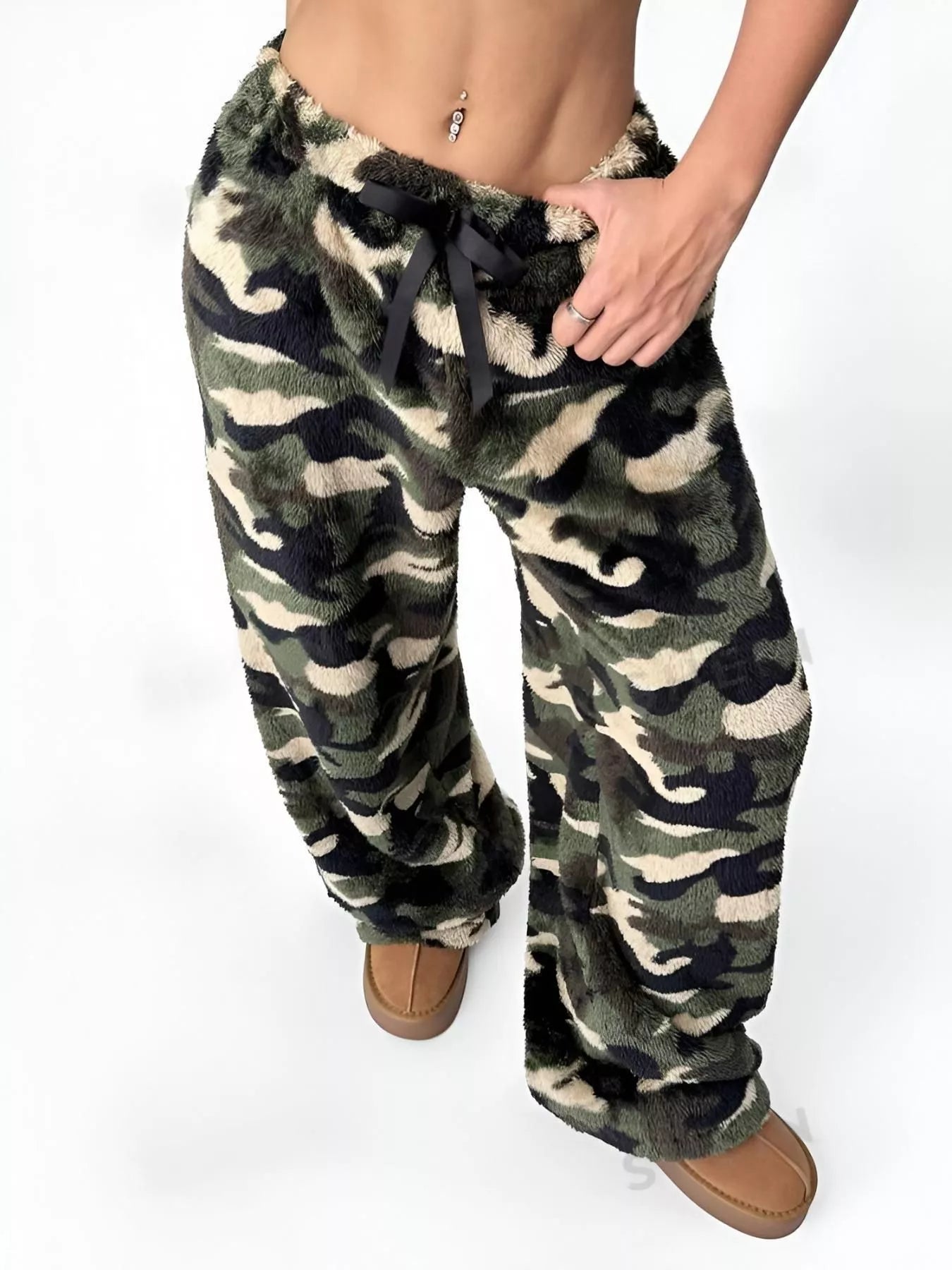 Camouflage patterned pants worn by a person on a white background