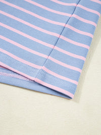 Close-up of a folded fabric with blue and pink horizontal stripes on a beige background