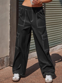 Person wearing black cargo pants standing against a metal shutter.