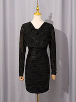 A black long-sleeve cowl-neck dress with floral lace applique, displayed on a cream mannequin with a gold finial against a light gray curtain backdrop.