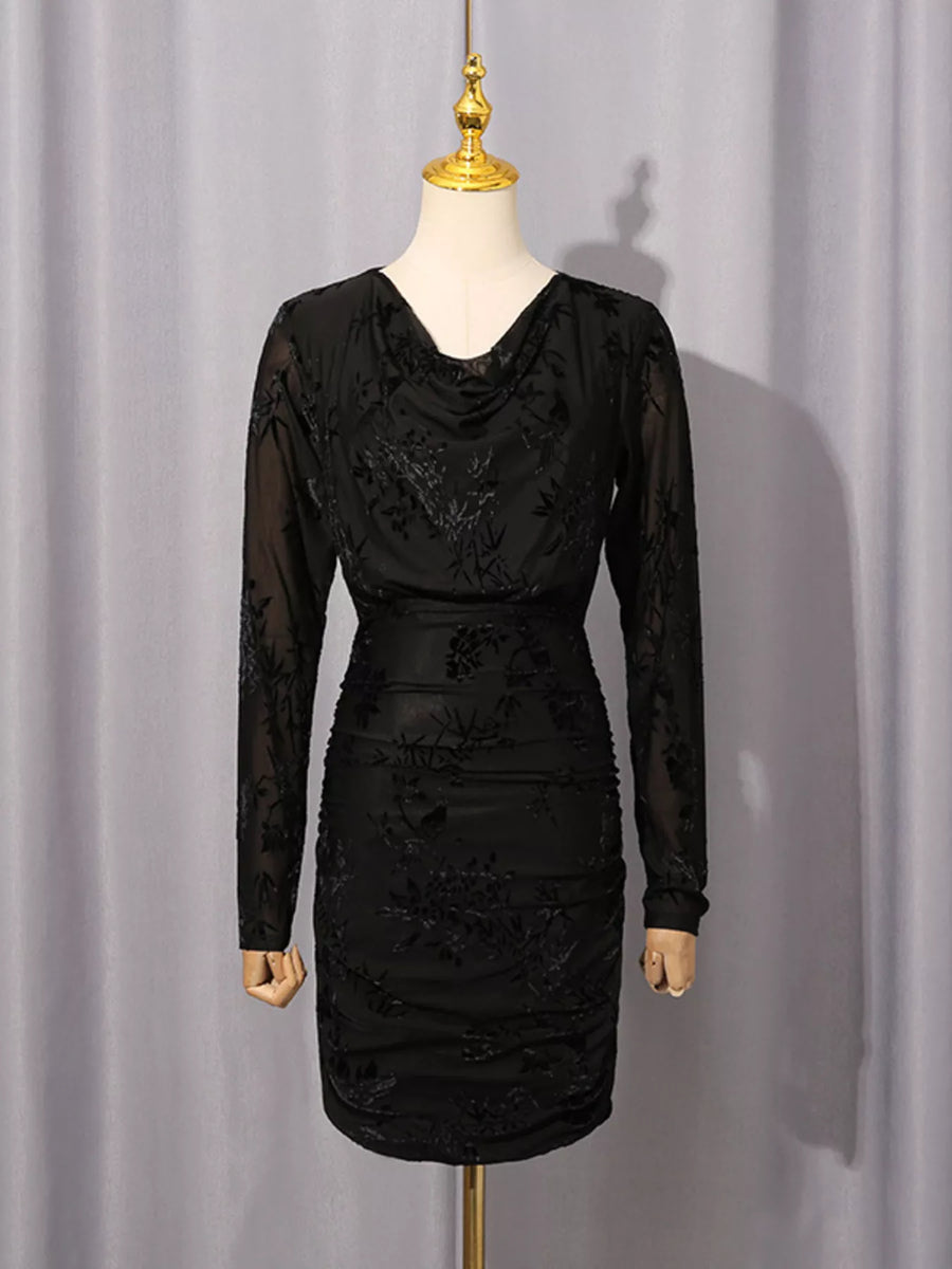 A black long-sleeve cowl-neck dress with floral lace applique, displayed on a cream mannequin with a gold finial against a light gray curtain backdrop.
