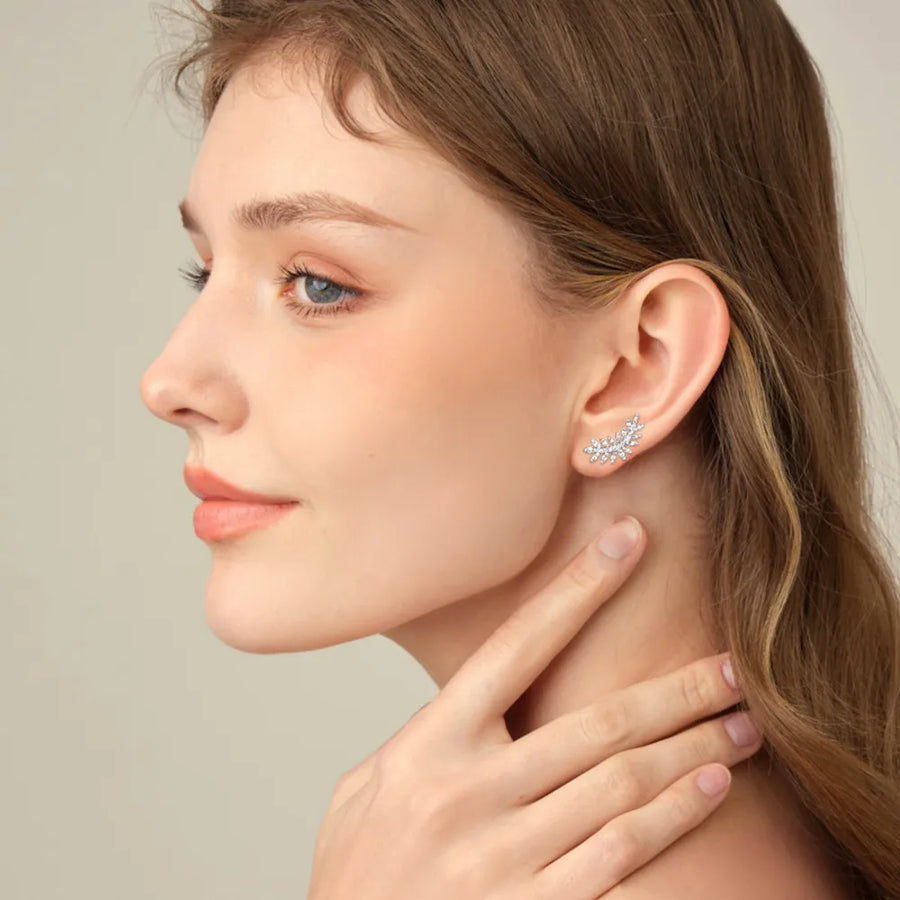 Woman wearing a delicate earring with a neutral background