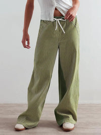 Person wearing green striped pants with a white background