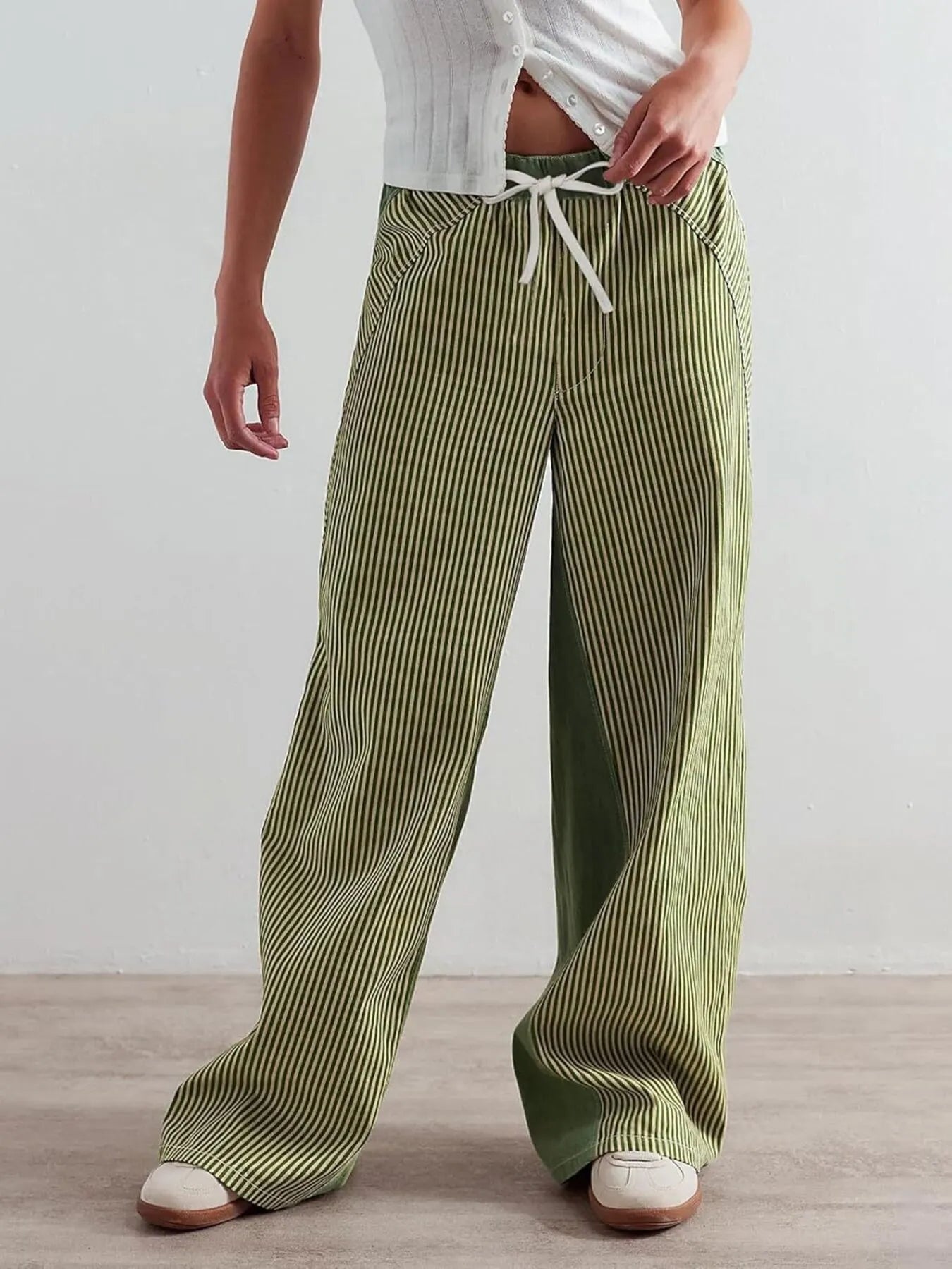 Person wearing green striped pants with a white background