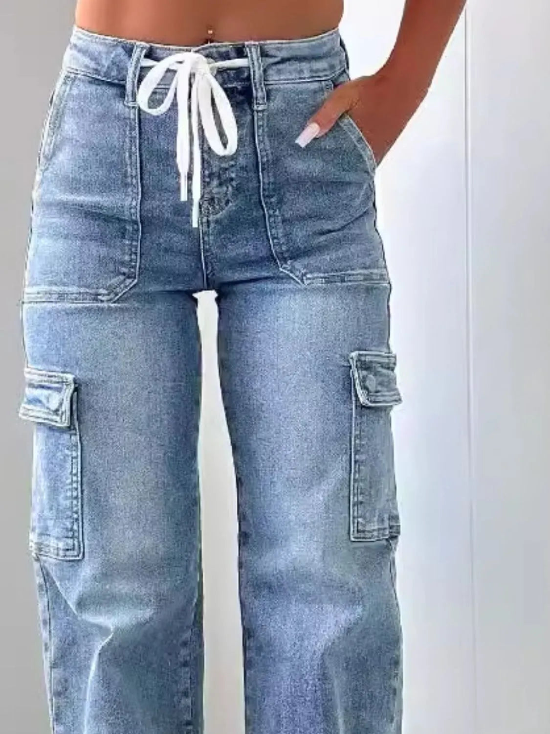 Blue cargo jeans with a drawstring waist on a white background
