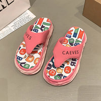 Pink sandals with colorful pattern on a gray surface