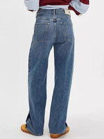 Blue jeans worn by a person on a white background