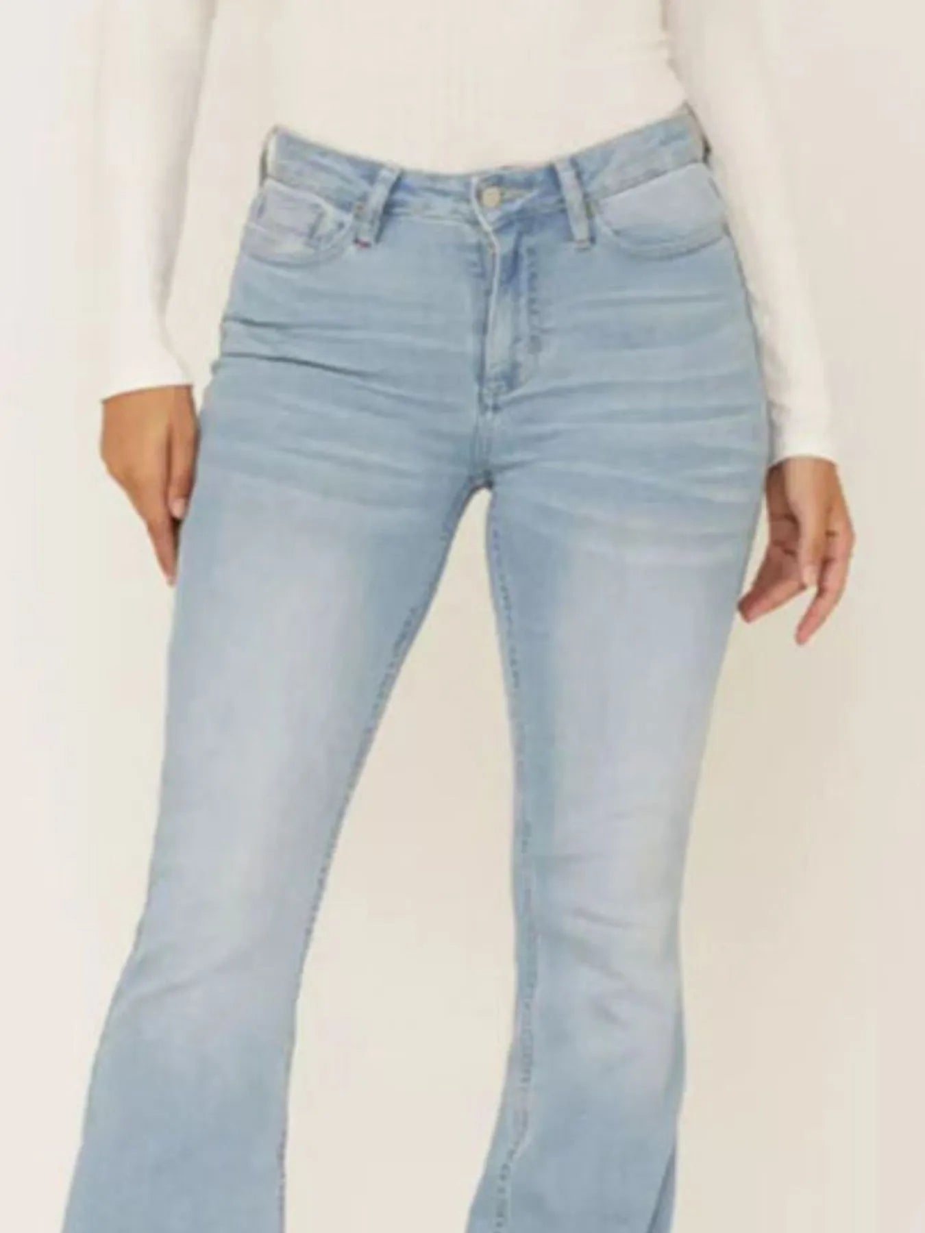Light blue jeans worn by a person on a white background
