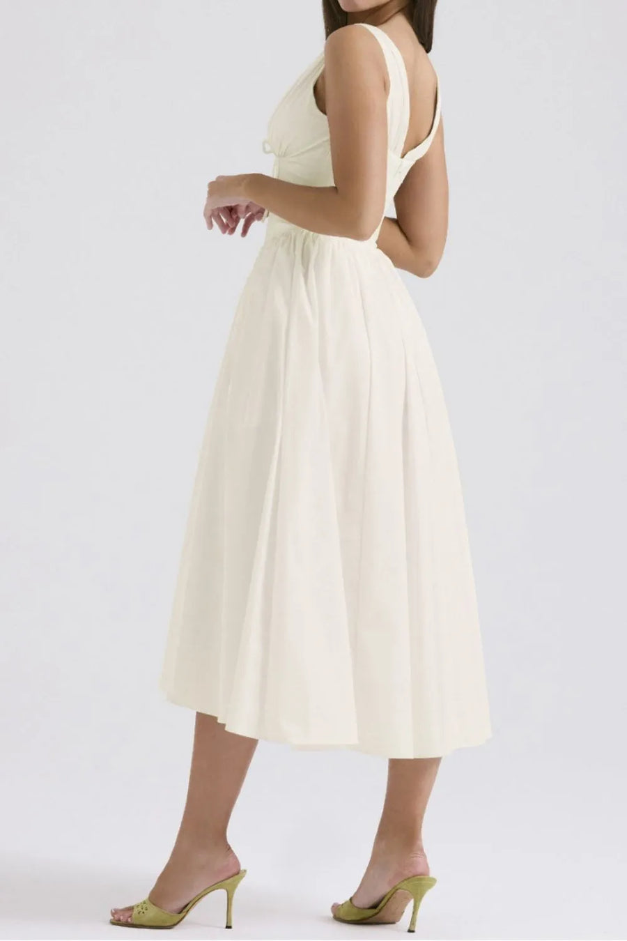 Woman wearing a white dress on a plain background