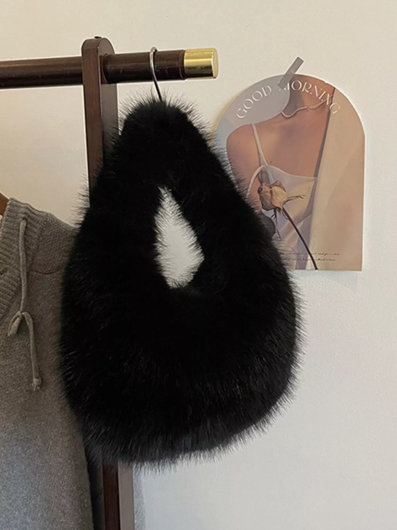 Black fur item hanging on a rack with a magazine in the background