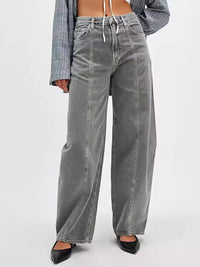 Person wearing gray wide-leg jeans on a white background