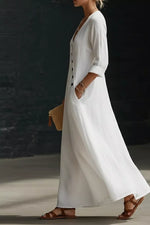 Woman wearing a long white dress with a dark background