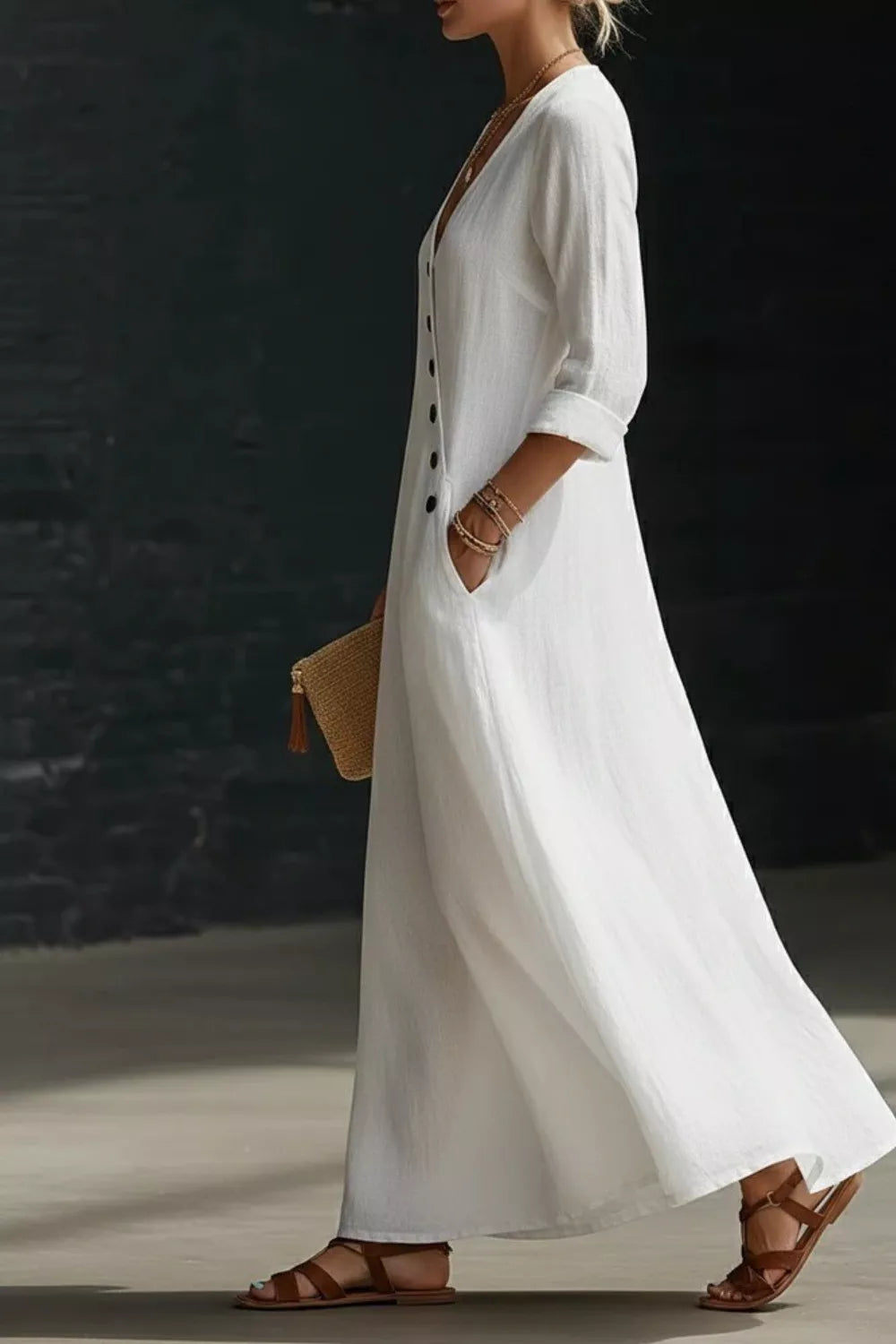 Woman wearing a long white dress with a dark background