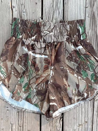 Camouflage-patterned shorts on a wooden surface