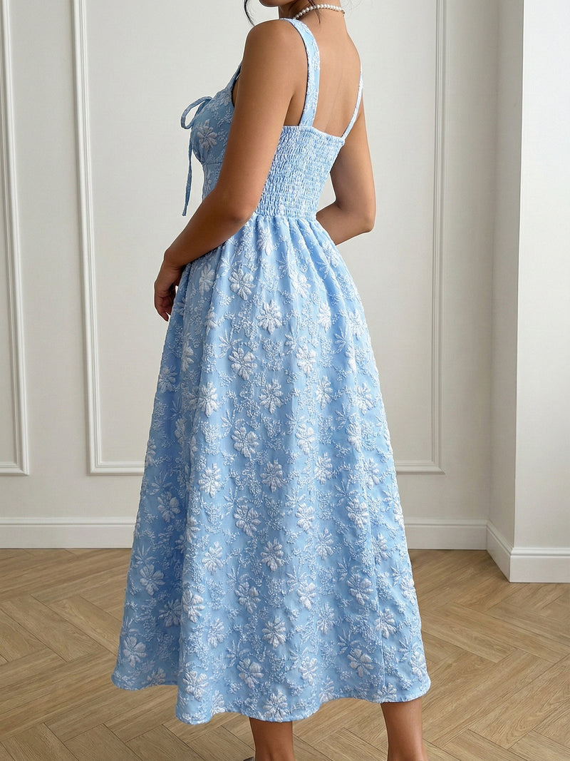 Light blue floral dress worn by a person against a white paneled wall.