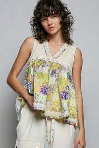 Woman wearing a colorful patchwork sleeveless top against a gray background