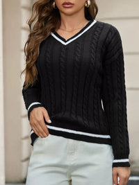 Person wearing a black cable knit sweater with white trim