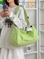 Person holding a light green handbag with a plush toy, standing in front of a white shelf.