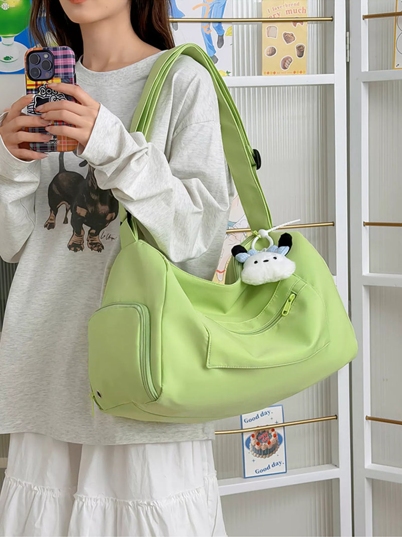 Person holding a light green handbag with a plush toy, standing in front of a white shelf.