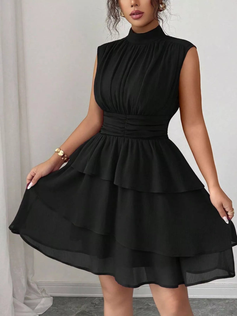 Black dress worn by a model against a neutral background