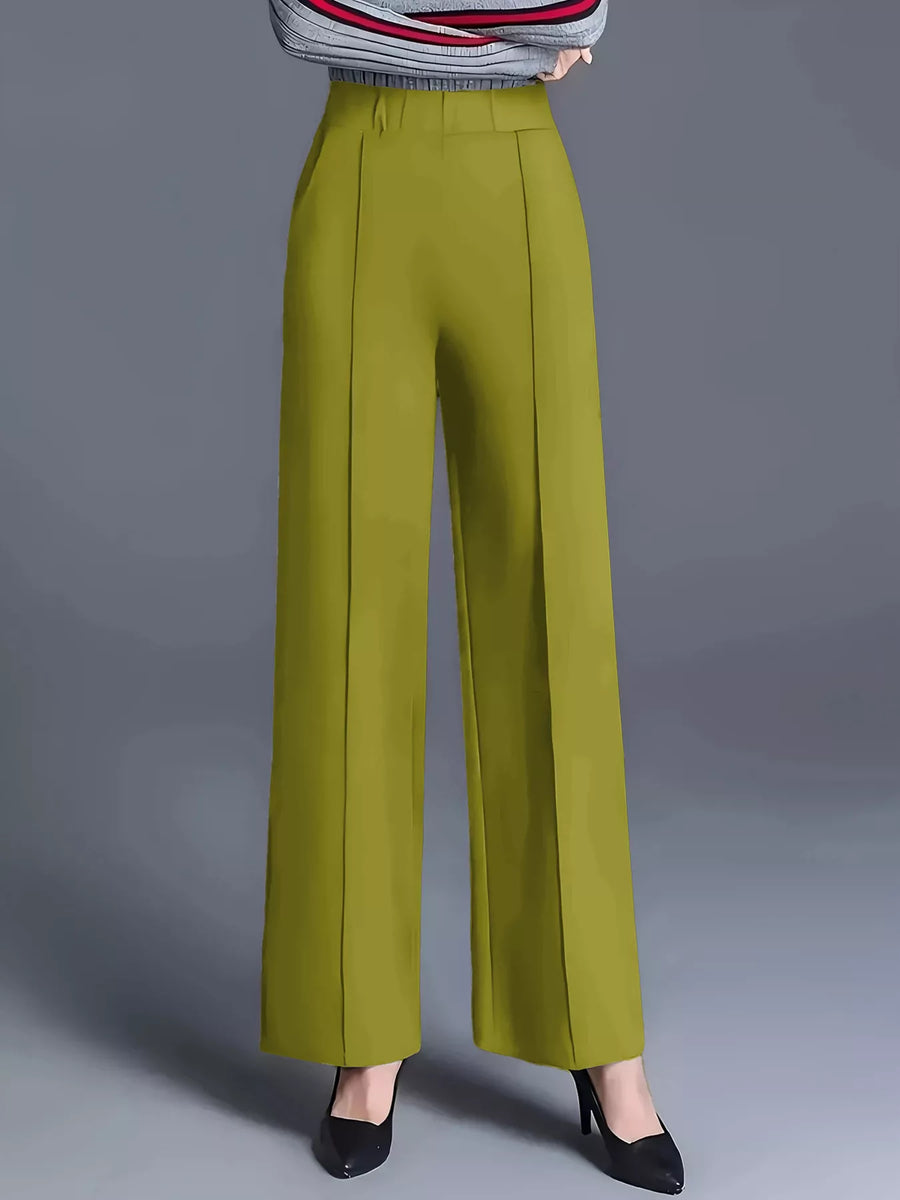 Green wide-leg pants worn with a striped sweater on a gray background