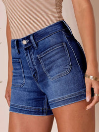 Person wearing blue denim shorts on a beige background