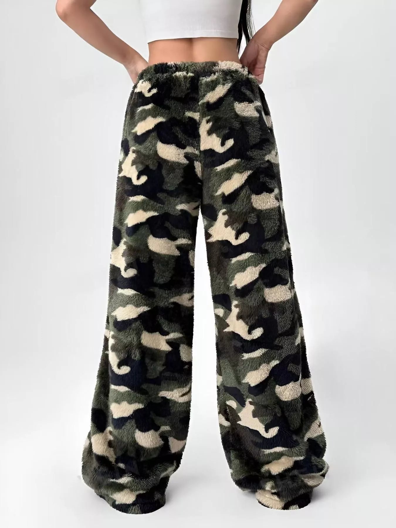 Camouflage patterned pants worn by a person on a white background
