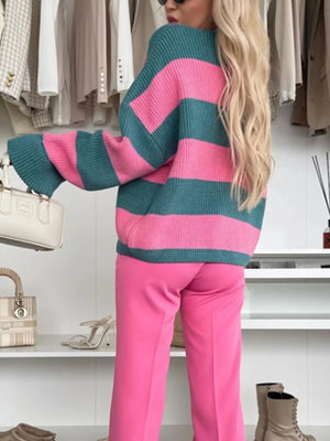 Person wearing a pink and teal striped sweater with pink pants in a clothing store.