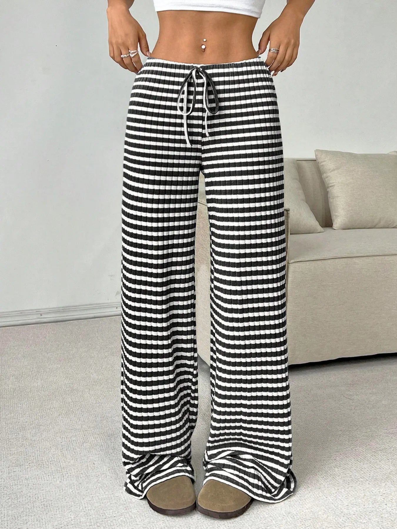 Person wearing black and white striped pants in a casual setting.