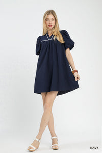 Woman wearing a navy dress on a white background