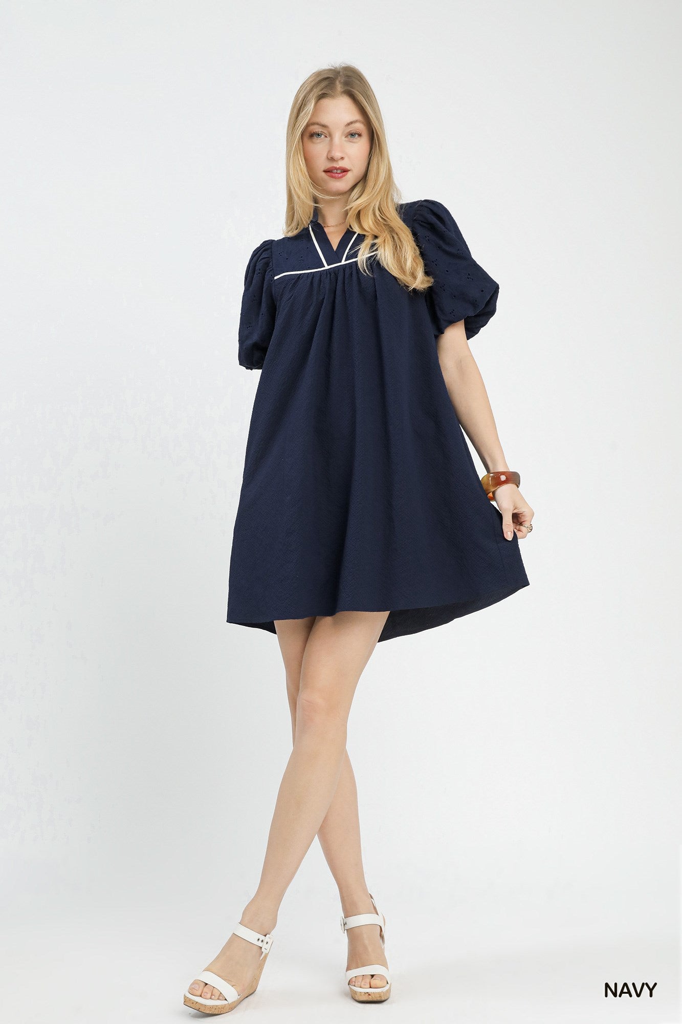 Woman wearing a navy dress on a white background