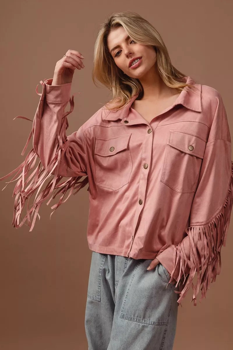 Woman wearing a pink fringe shirt against a brown background