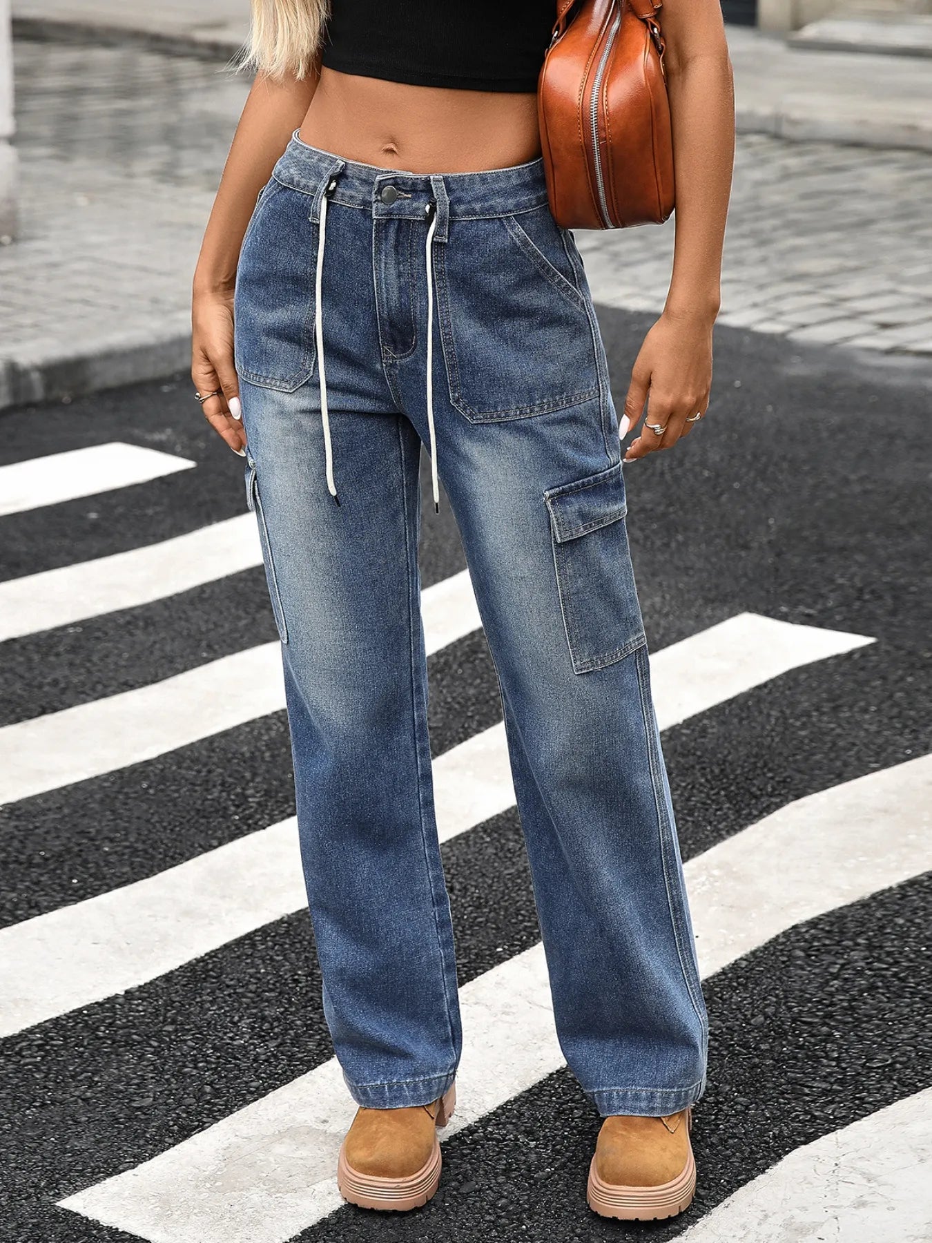 Person wearing blue jeans and brown shoes on a zebra crossing