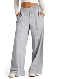 Gray sweatpants worn by a person on a white background