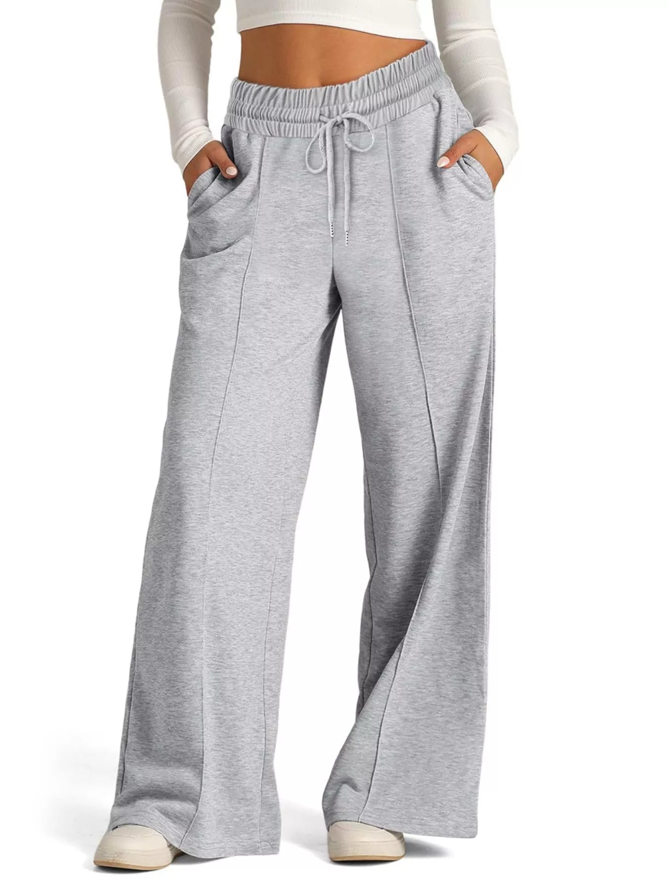 Gray sweatpants worn by a person on a white background