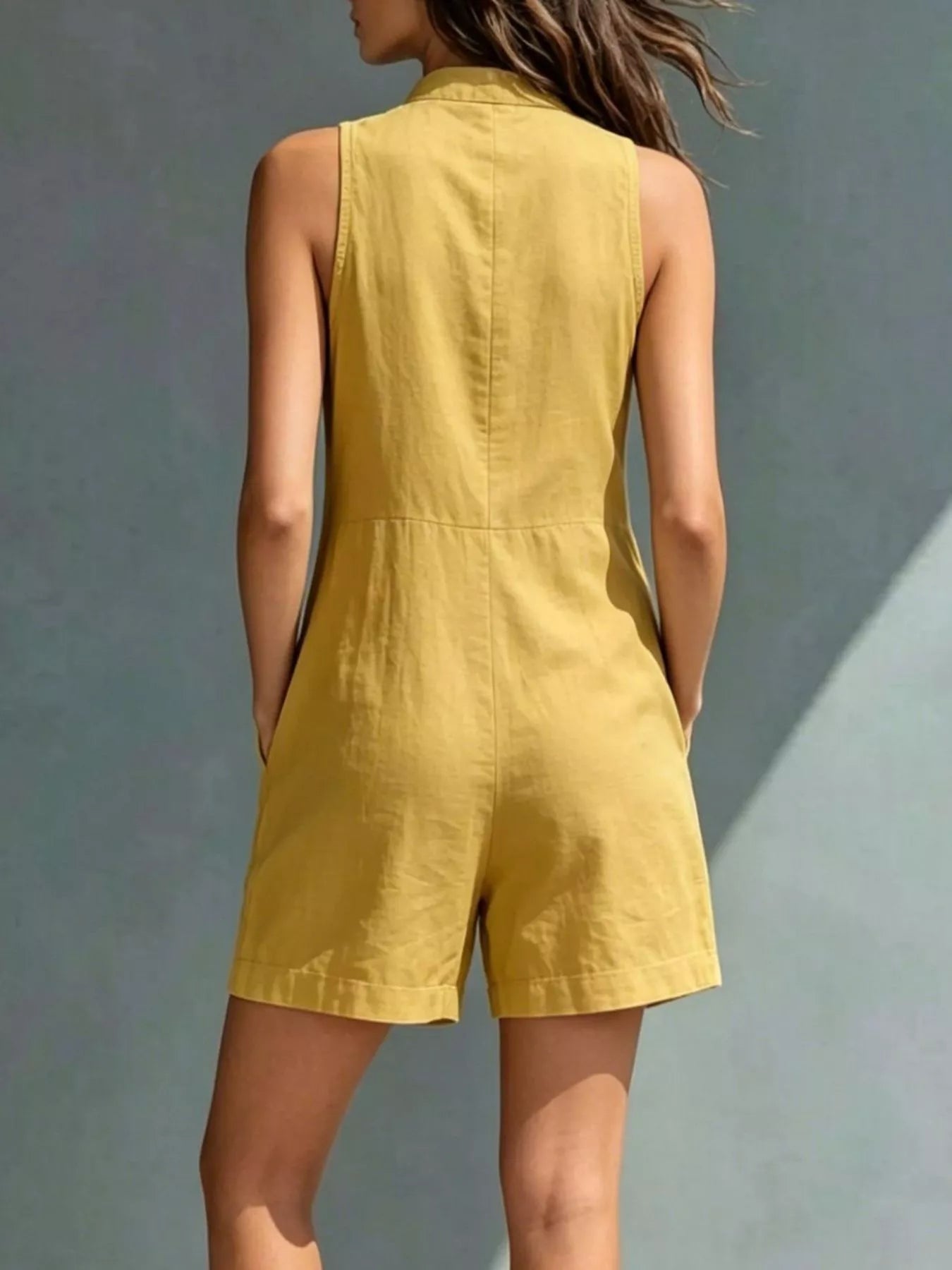 Yellow sleeveless dress worn by a person against a gray background