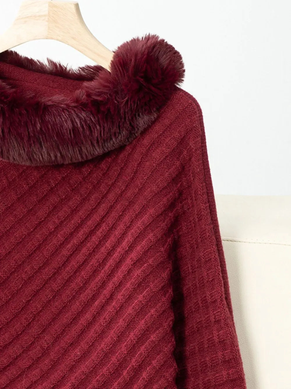 Maroon ribbed sweater with fluffy collar on a hanger against a white background