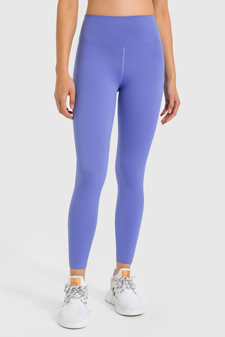 Person wearing purple leggings on a white background