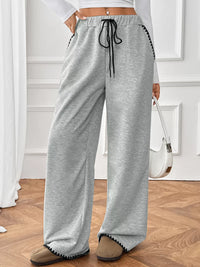 Person wearing gray sweatpants with a white background
