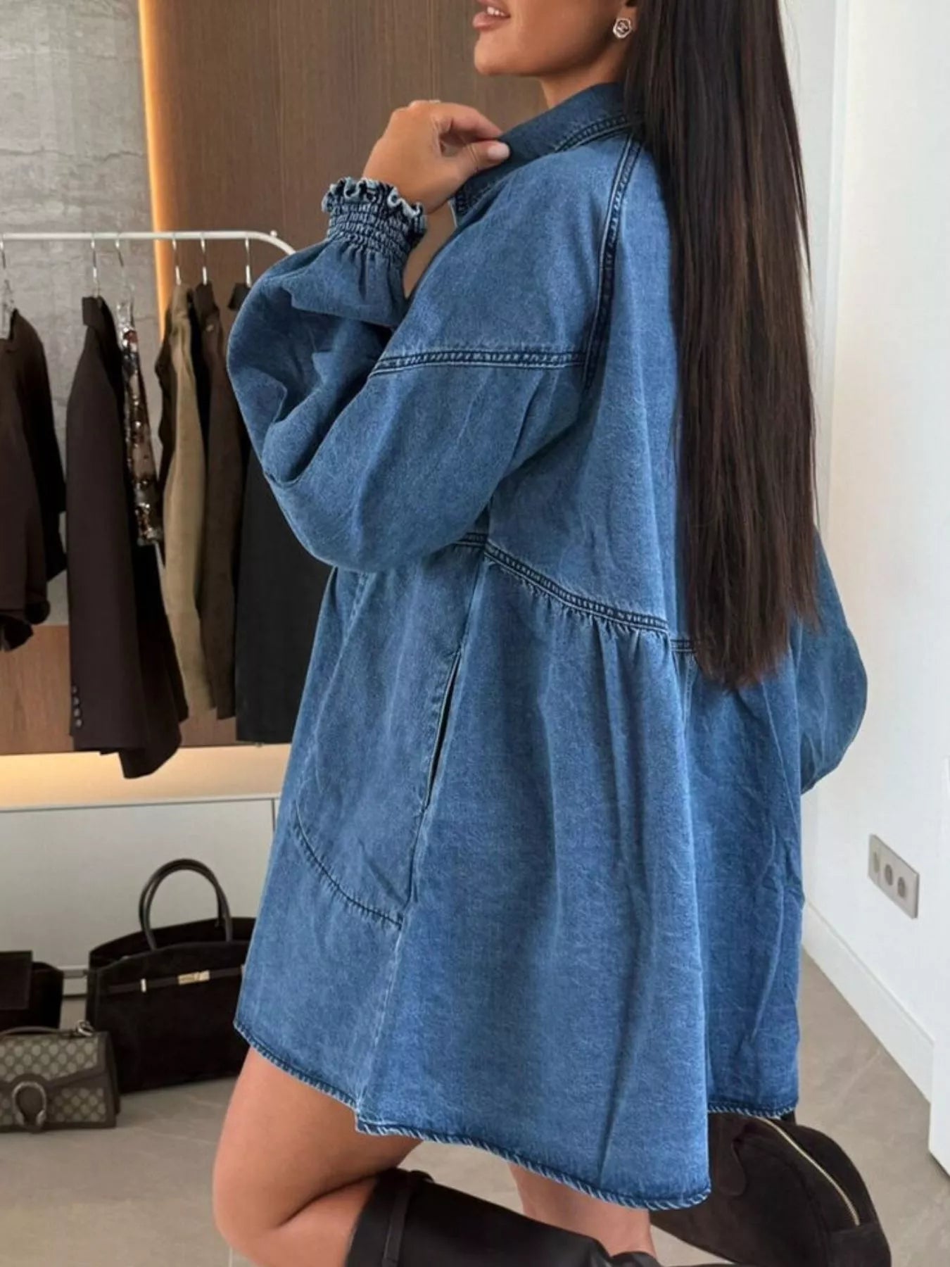 Person wearing a blue denim dress in a clothing store.