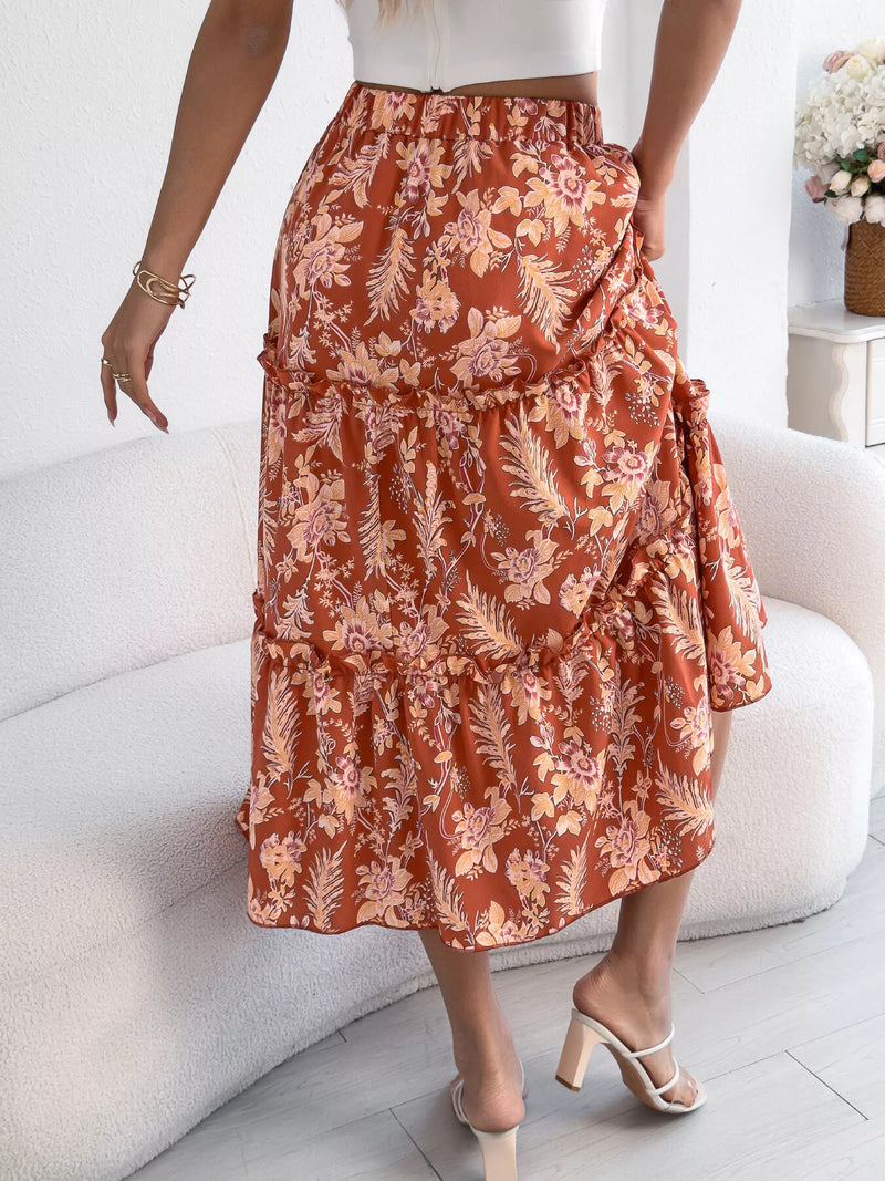 Person wearing a rust-colored floral skirt sitting on a white couch.