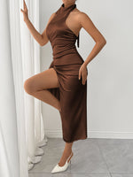 Woman wearing a brown halter neck dress with white shoes in a minimalistic setting