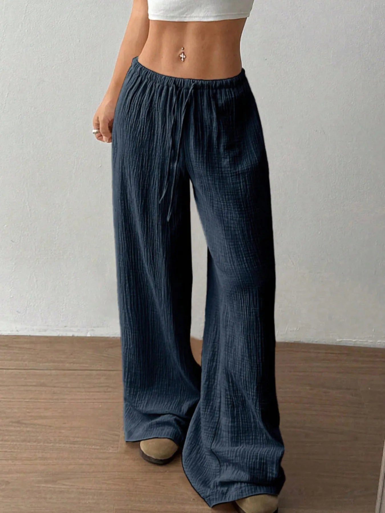 Person wearing blue wide-leg pants against a plain background