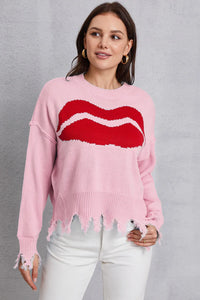 Woman wearing a pink sweater with red lips design against a gray background