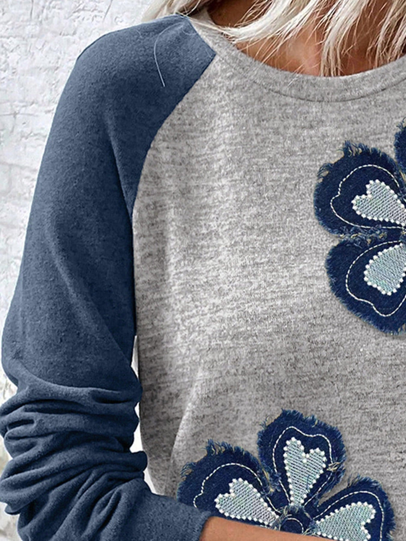 Gray and blue sweatshirt with floral patterns on a white background