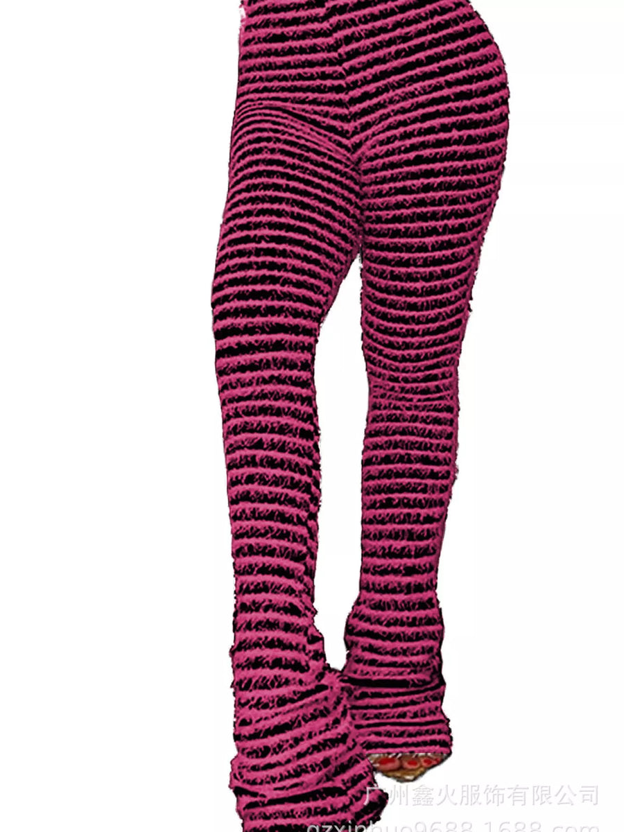 A close-up side view of a person wearing textured, ribbed knit leggings in a dark pink and black striped pattern, cropped from the waist down against a plain white background.