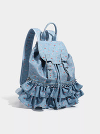Denim backpack with ruffled bottom on a light gray background