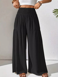 Black wide-leg pants worn by a person on a white background